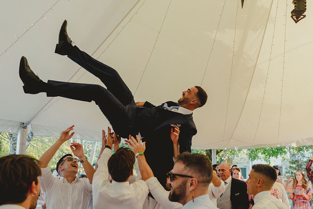 Novio manteado por amigos en la boda