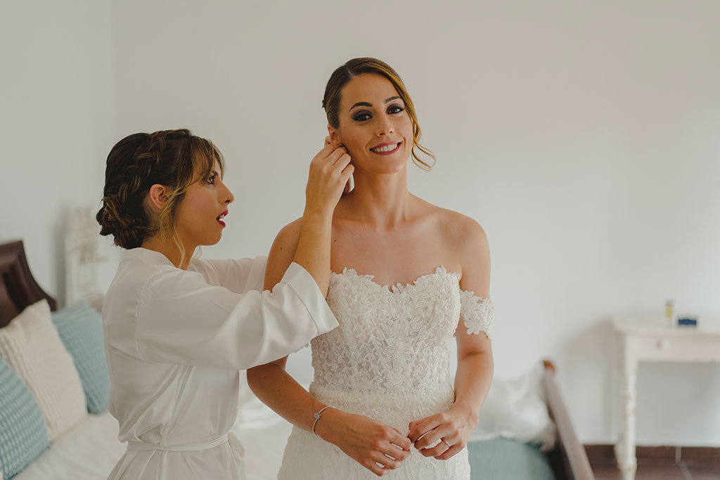 Fotografía de novia poniendose los pendientes para ir a su boda