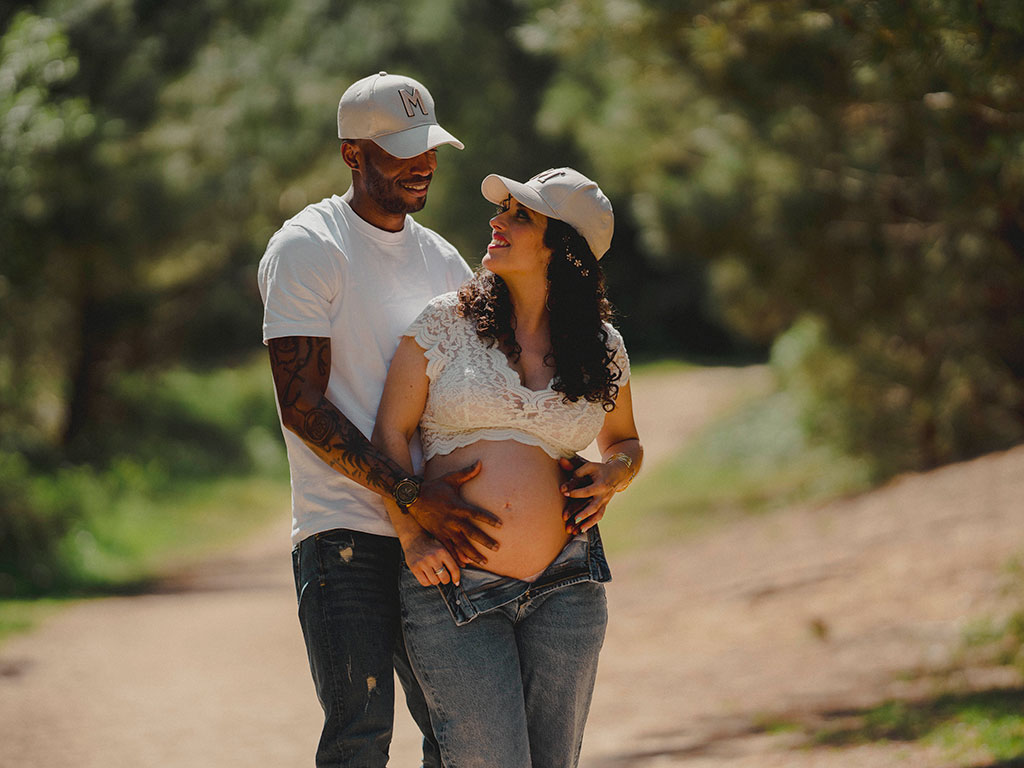 Pareja con gorras en reportaje de embarazo